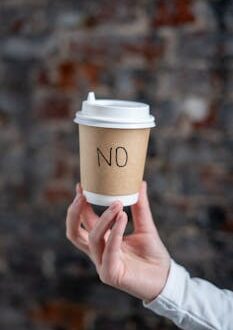 A Person Holding a Paper Cup with the Word No